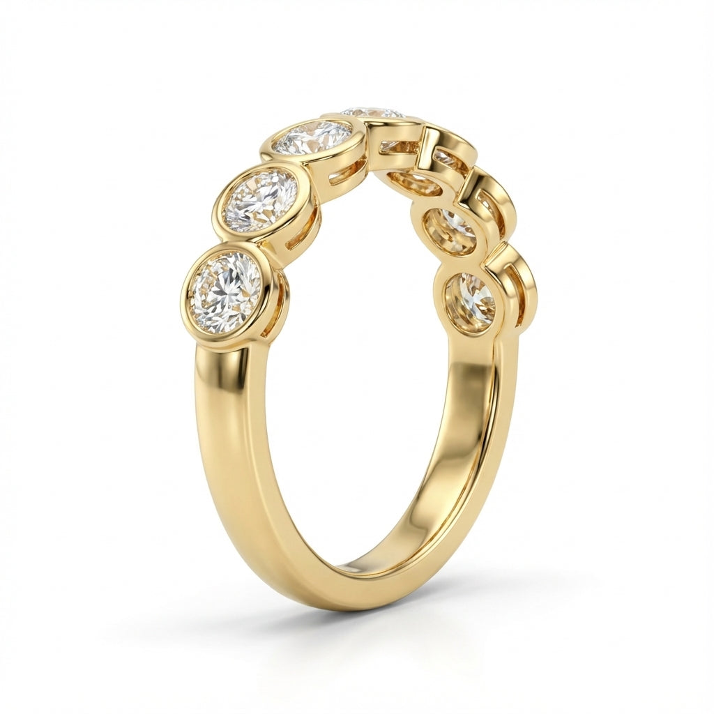 Gold ring with round diamonds set in a sleek, elegant design, creating a luxurious and timeless appearance against a plain backdrop.
