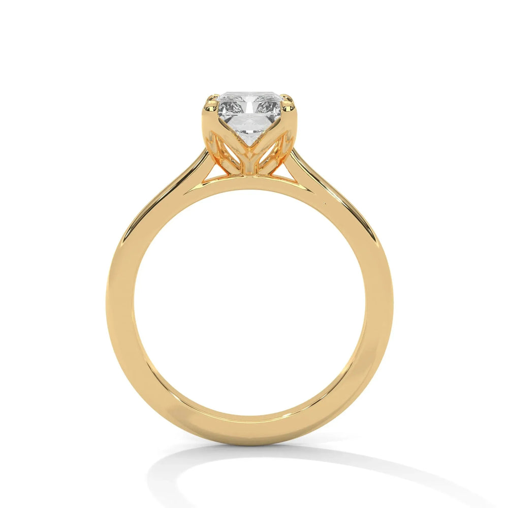 Gold ring with a single round diamond in a prong setting. The band is smooth and reflective, exuding elegance and sophistication against a white backdrop.