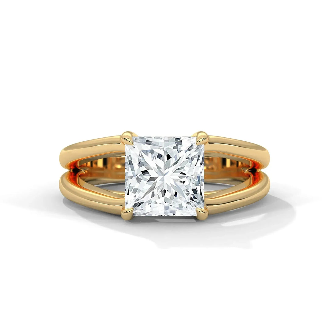 A gold ring with a split shank design featuring a large, sparkling princess cut diamond in a four-prong setting. Elegant and luxurious tone.