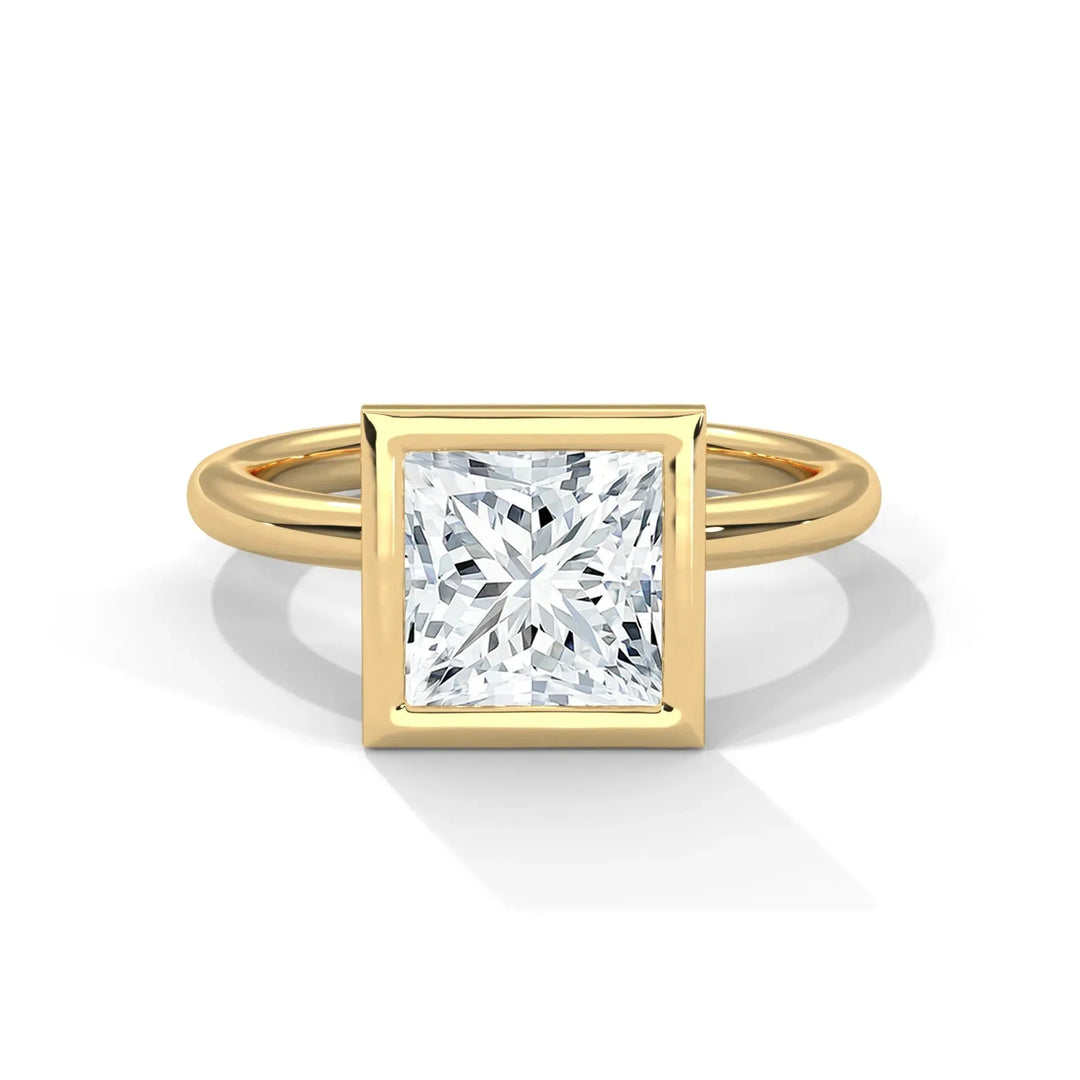 A gold ring with a square, radiant-cut diamond set in a sleek bezel setting. The minimal design conveys elegance and sophistication.