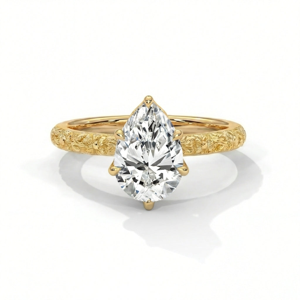 Gold ring with a pear-shaped diamond on a white background