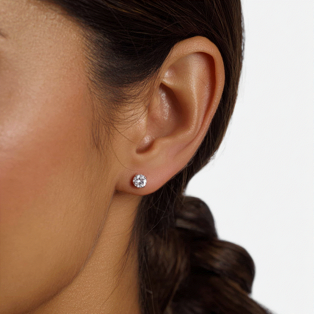 Lab-grown diamond round four-prong stud earring in 14k white gold worn on ear