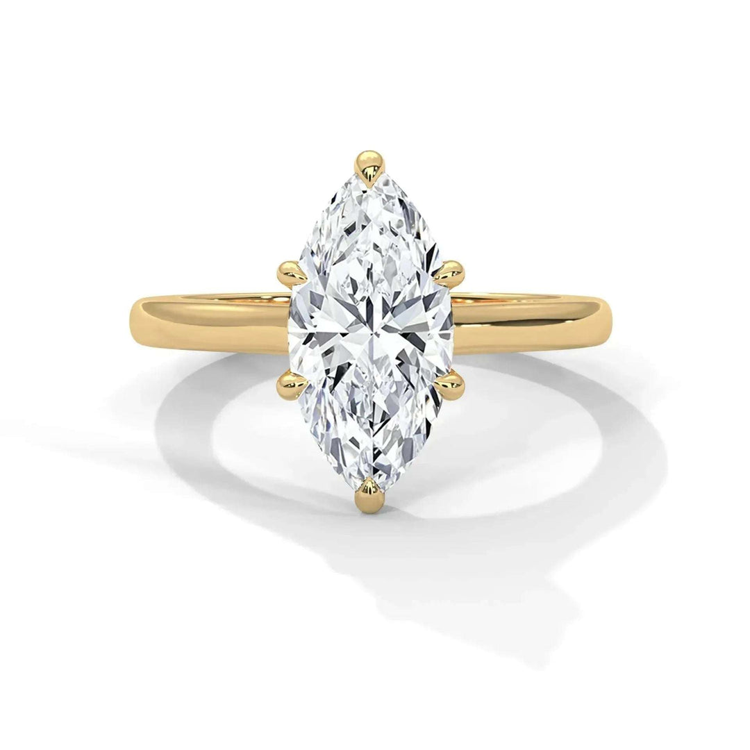 A marquise-cut diamond ring with a gold band, elegantly designed. The diamond sparkles brilliantly, creating a luxurious and sophisticated vibe.