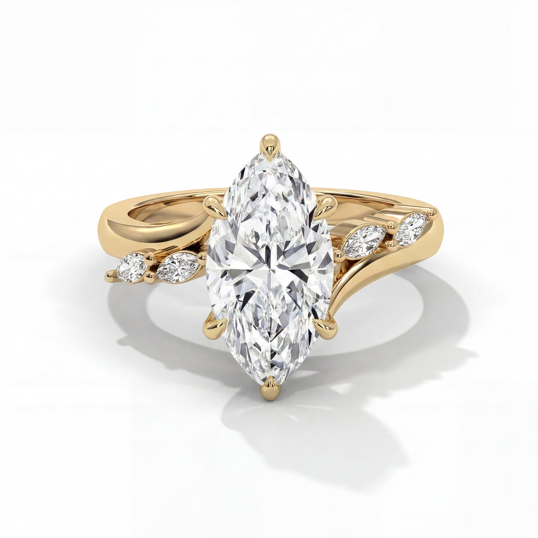 A marquise-cut diamond ring set in gold, featuring a central diamond flanked by smaller diamonds in a leaf pattern. The design is elegant and sophisticated.