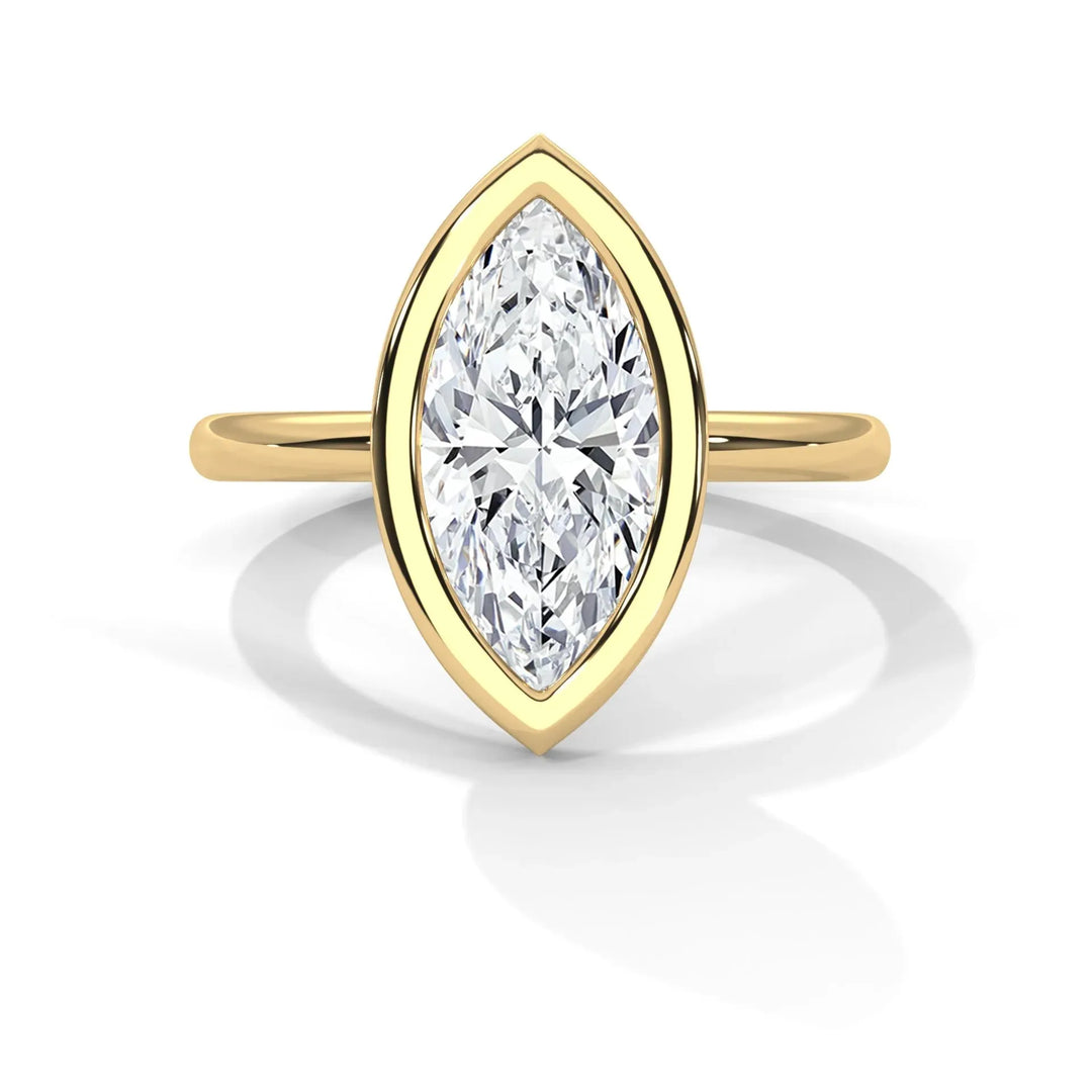 A marquise-cut diamond ring set in a yellow gold band. The diamond is elegantly elongated, creating a classic and sophisticated look. The overall tone is luxurious.