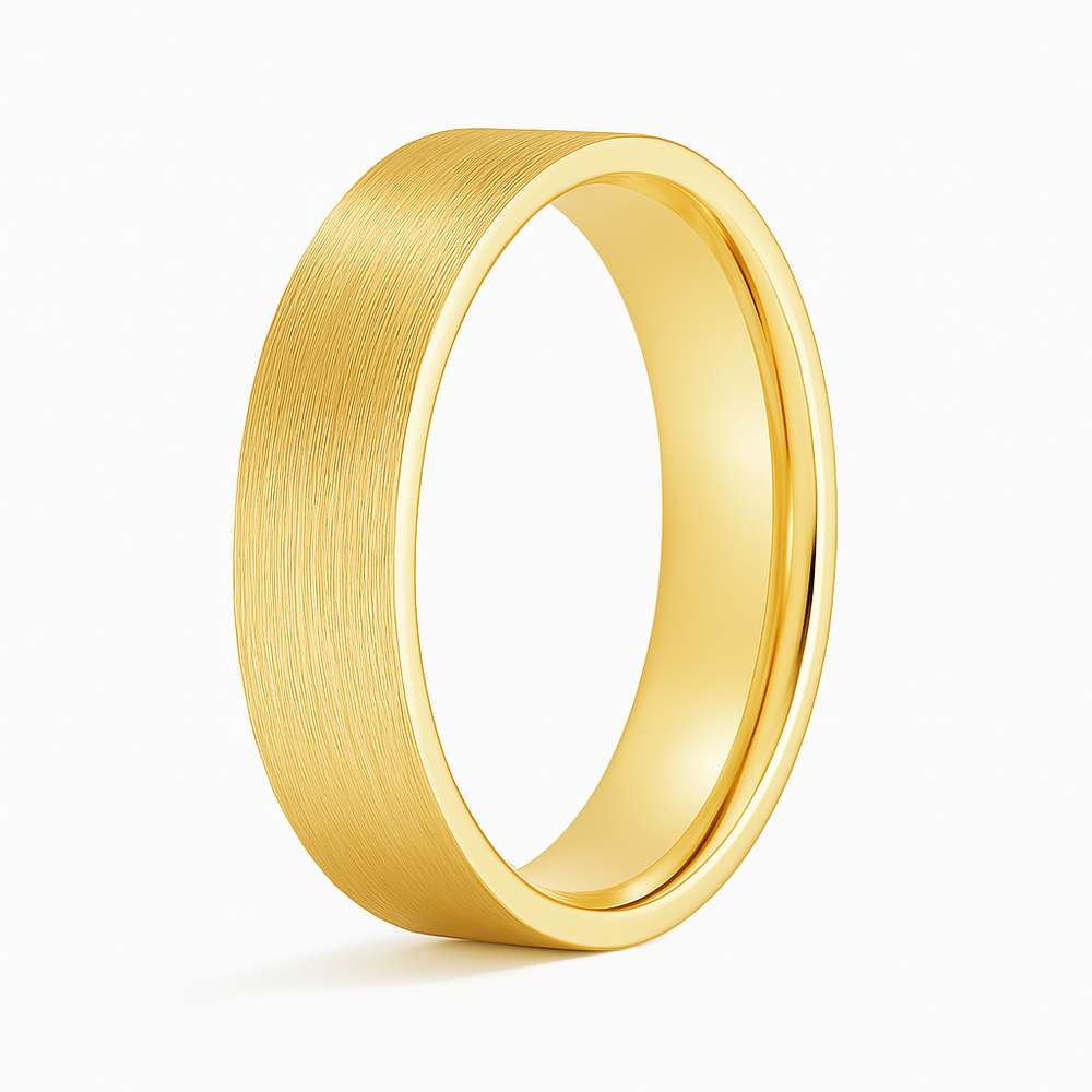 A matte brushed gold ring with a wide band, elegantly angled against a white background, conveying simplicity and sophistication.