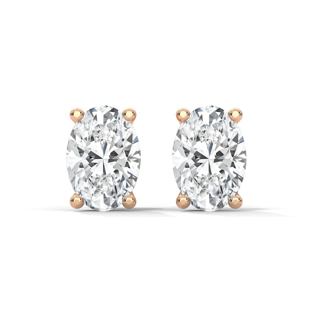 Oval cut diamond stud earrings with rose gold prongs on white background.