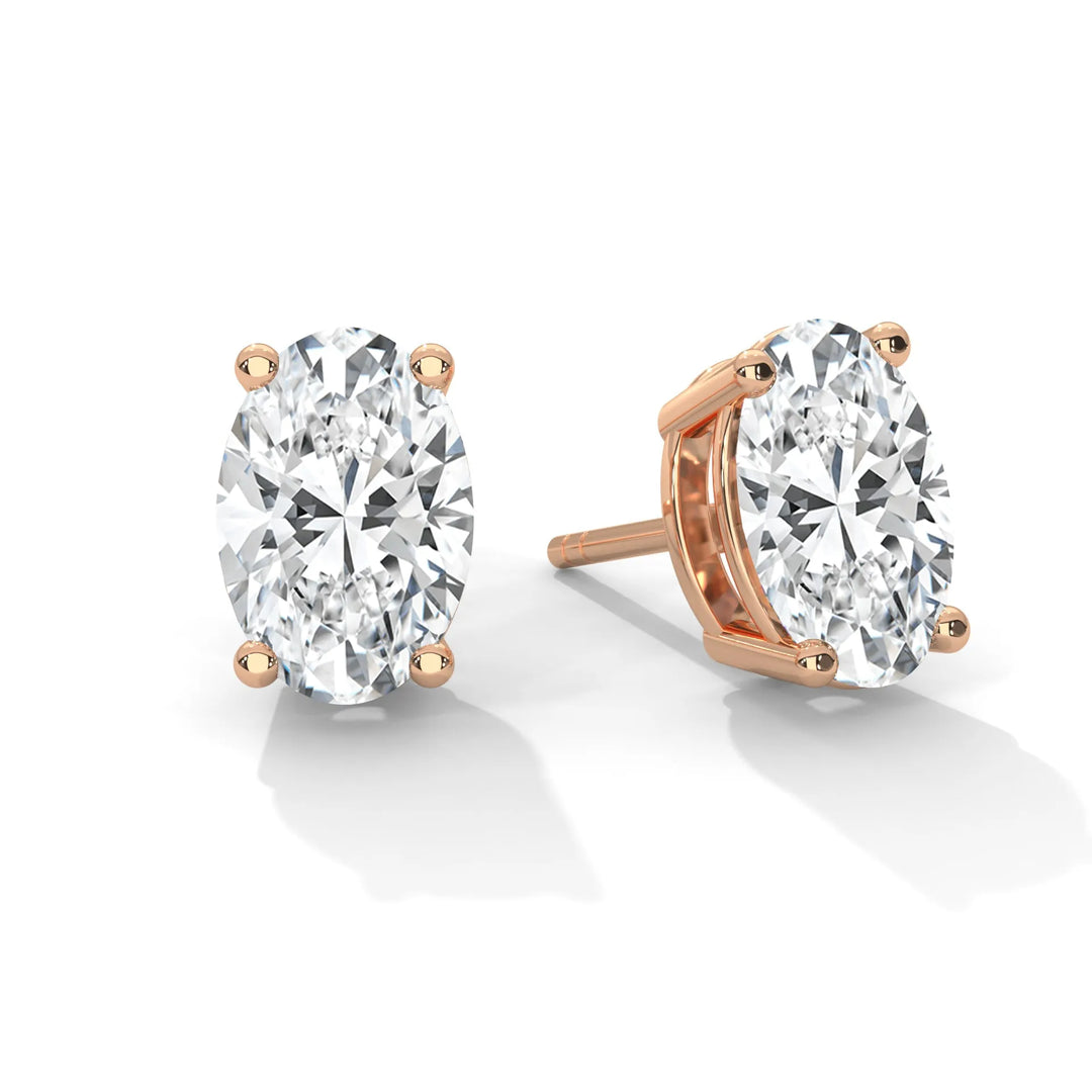 Oval diamond stud earrings in a rose gold four prong setting.