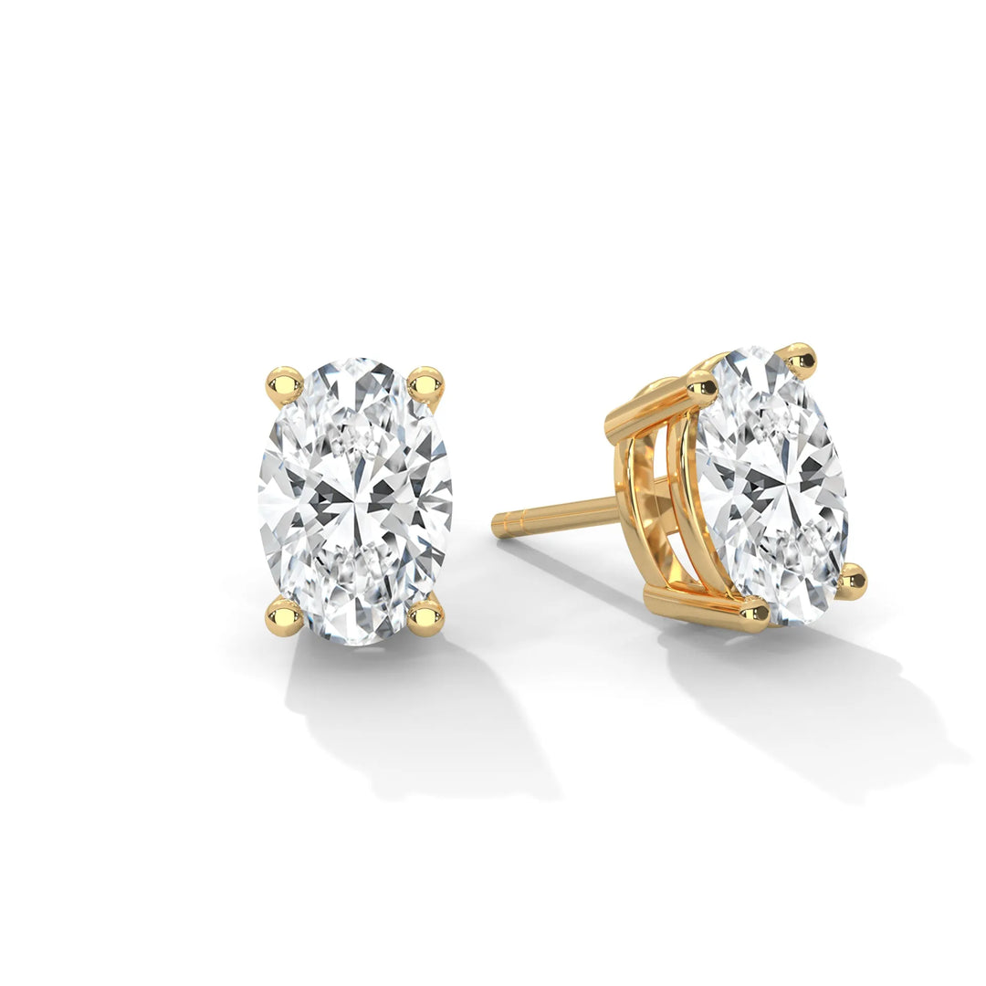 A pair of oval cut diamond stud earrings set in gold.