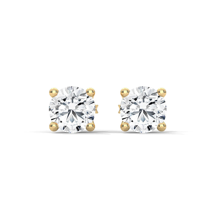 Pair of cushion cut diamond stud earrings with gold settings on a white background.