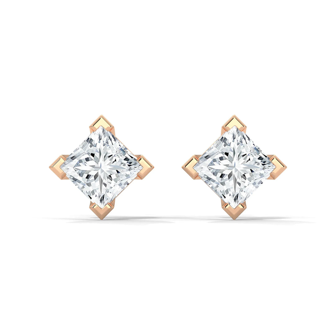 A pair of diamond stud earrings with gold prongs on a white background.