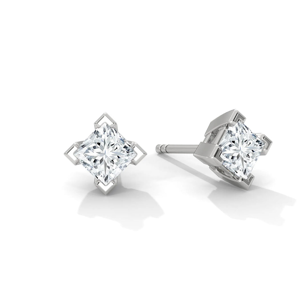 Pair of diamond stud earrings with a silver setting on a white background.