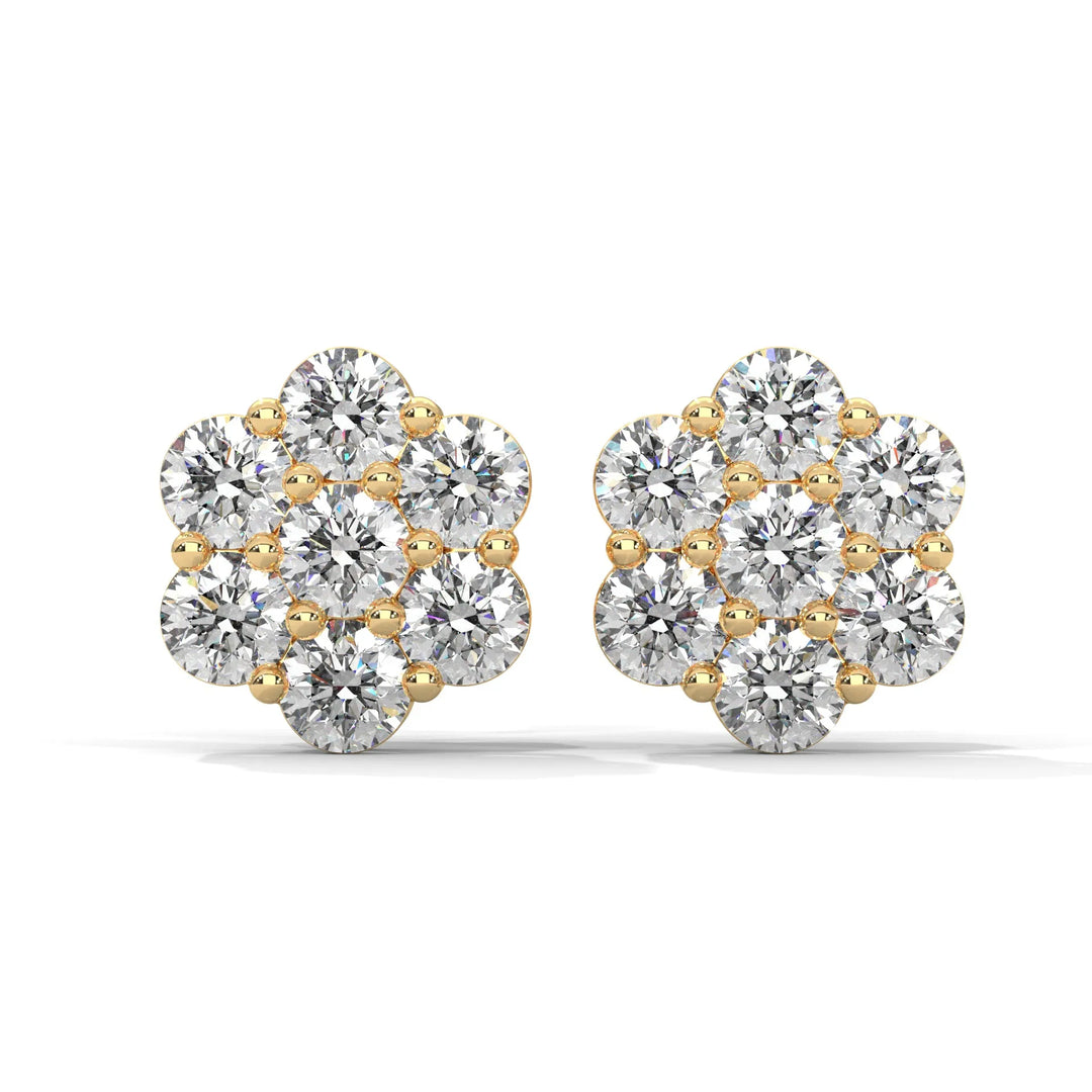 A pair of flower shaped diamond earrings with gold settings on a white background.