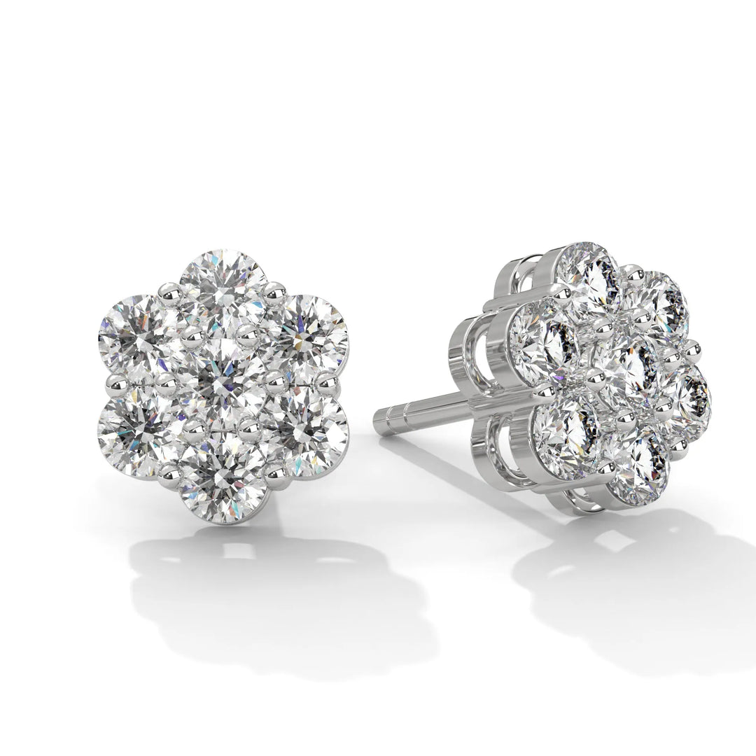 Pair of flower shaped diamond earrings on a white background.