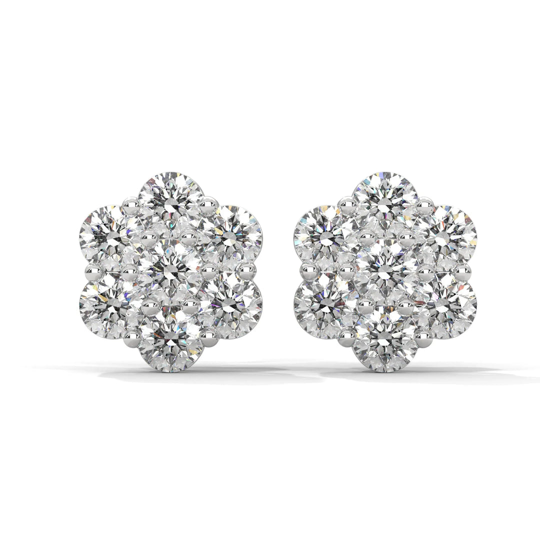 A pair of flower shaped diamond earrings on a white background.