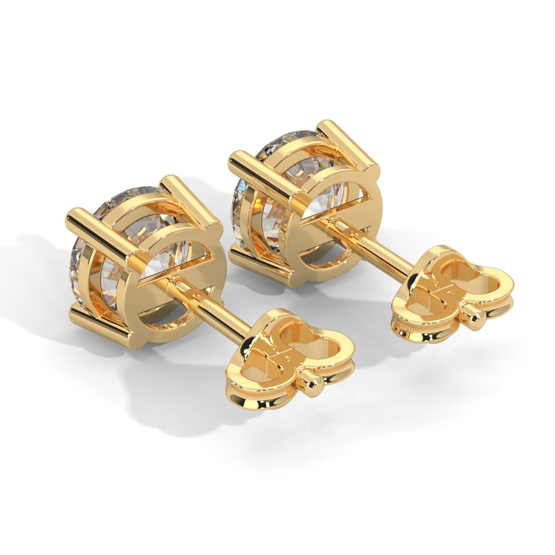 A pair of gold cufflinks with clear gemstone centers on a white background.