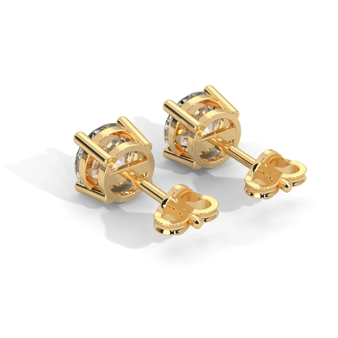 A pair of gold cufflinks with a clear stone set in a classic design on a white backdrop.