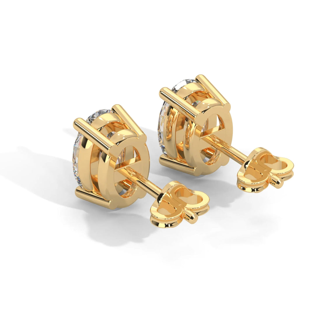 A pair of gold diamond stud earrings on a white background.