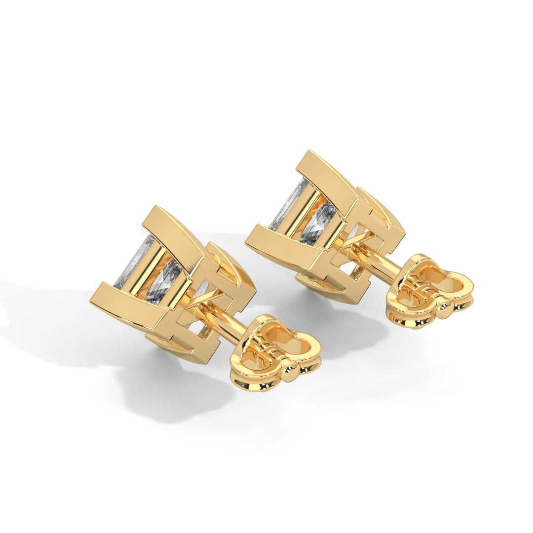 A pair of golden cufflinks with a rectangular clear gemstone centerpiece.