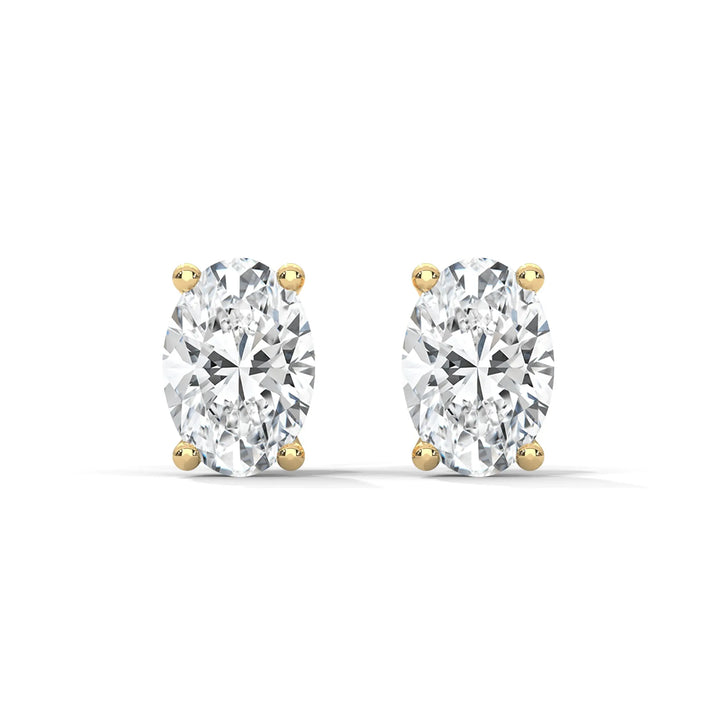 A pair of oval cut diamond stud earrings with gold settings on a white background.