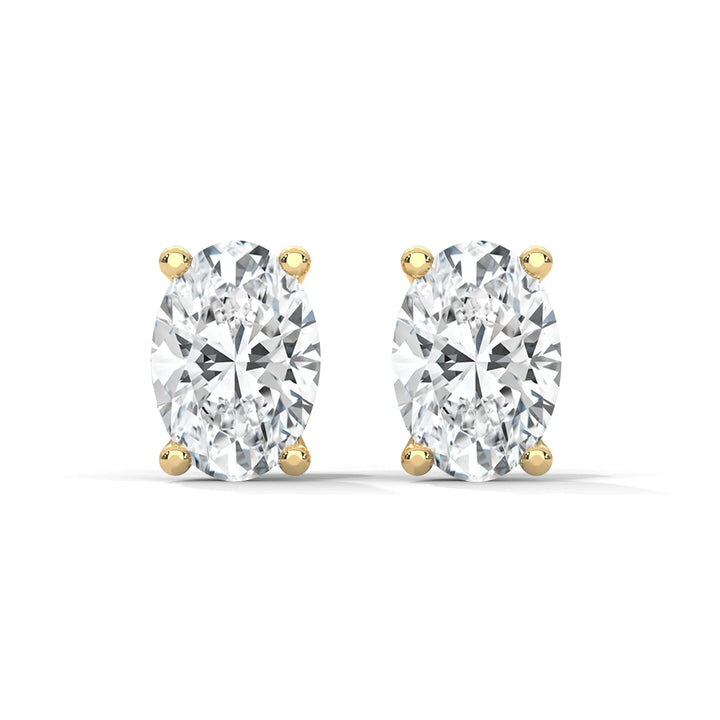 A pair of oval cut diamond stud earrings with gold settings on a white background.