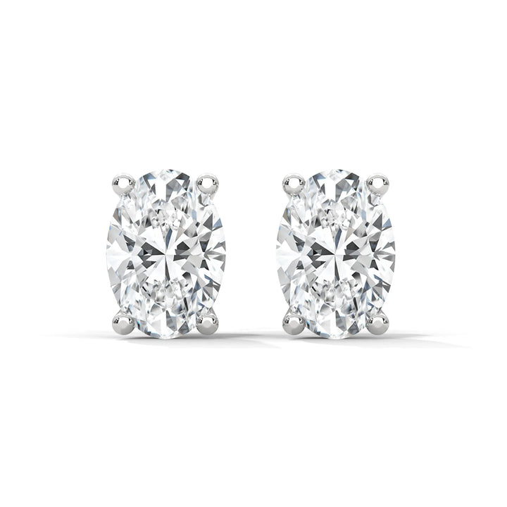 Pair of oval cut diamond stud earrings with silver settings on a white background.