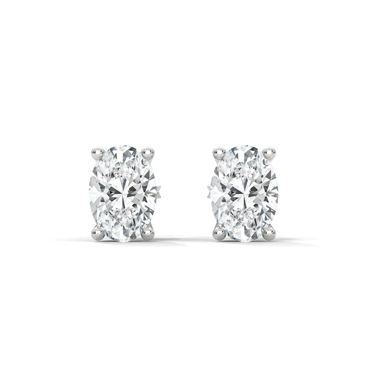 A pair of oval cut diamond stud earrings on a white background.