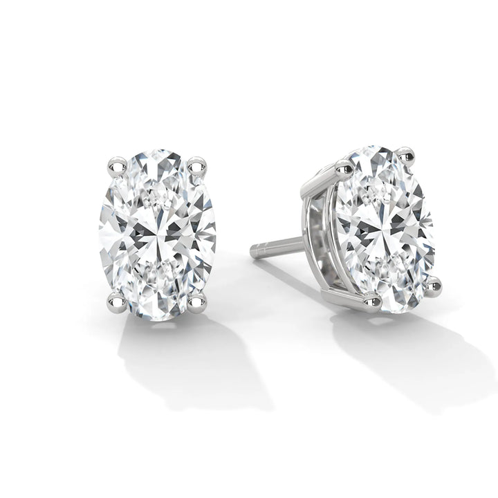 A pair of oval cut diamond stud earrings in white gold settings.