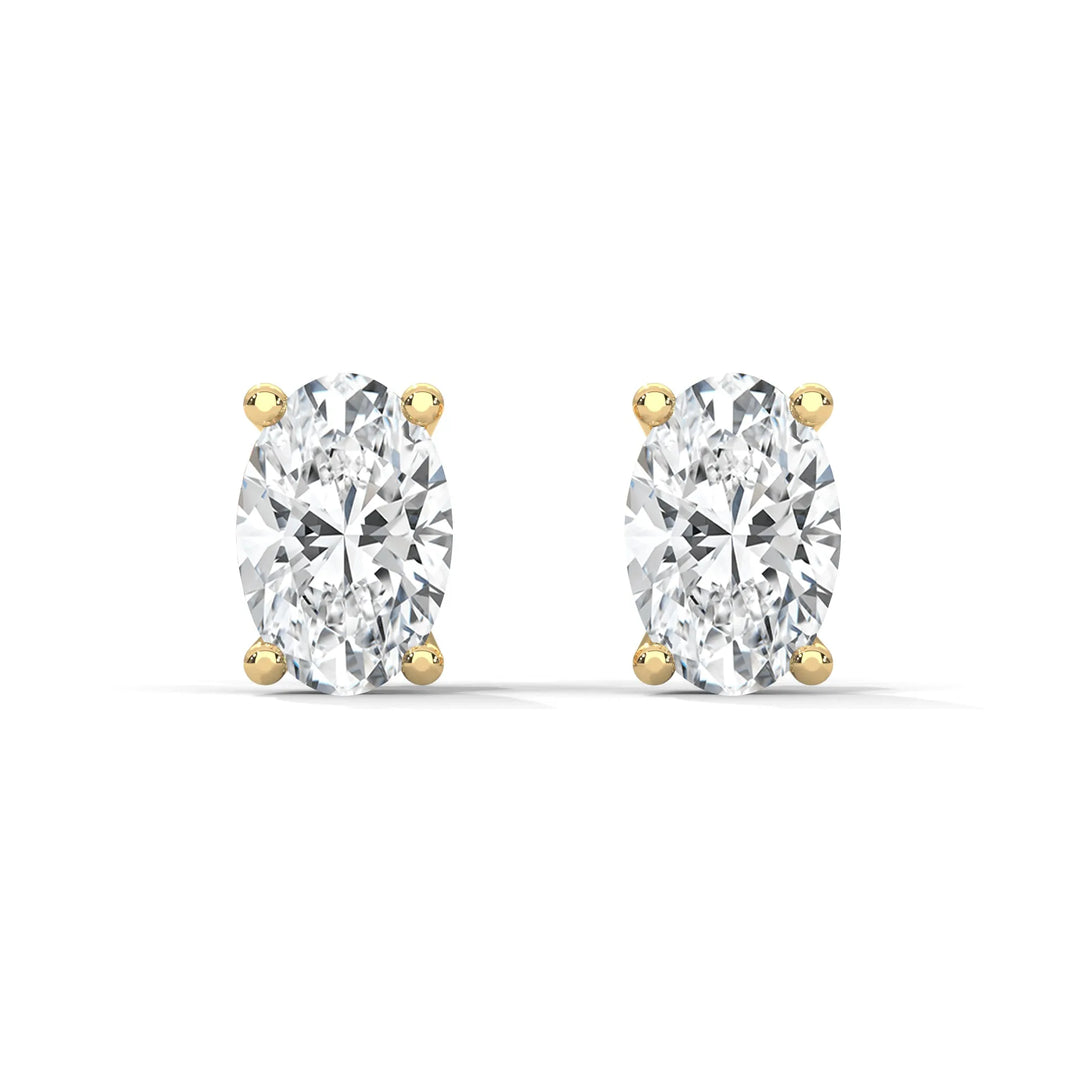 A pair of oval cut diamond stud earrings with yellow gold settings.