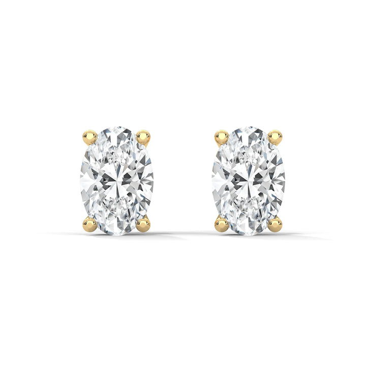 A pair of oval cut diamond stud earrings with yellow gold settings.