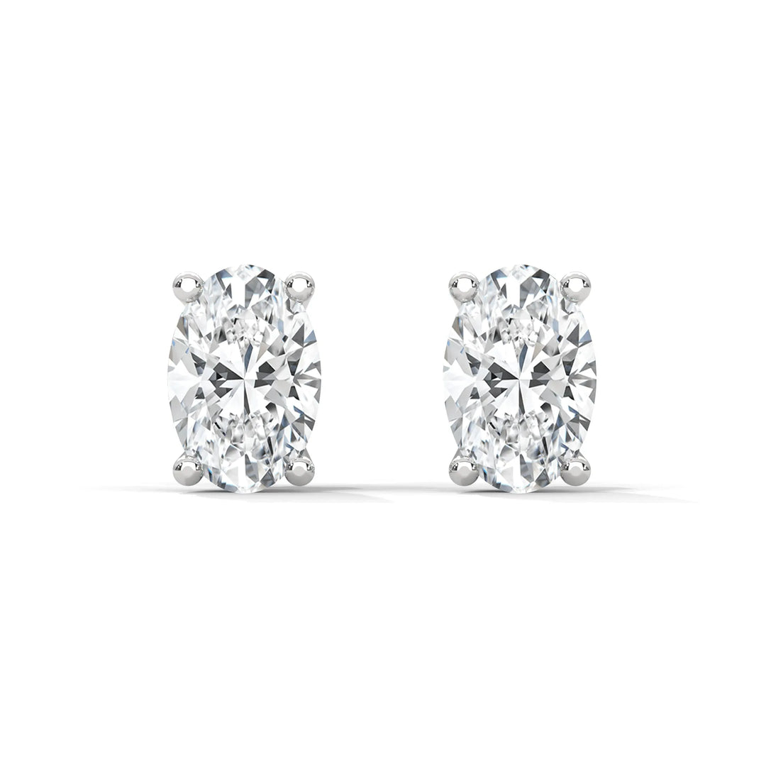 A pair of oval cut diamond stud earrings on a white background.