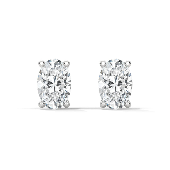 A pair of oval cut diamond stud earrings on a white background.