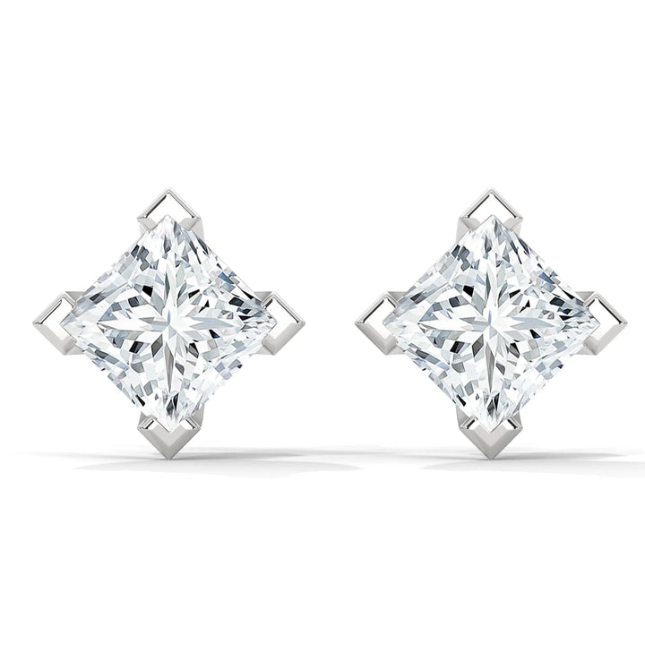 Pair of princess cut diamond earrings with silver settings on a white background.