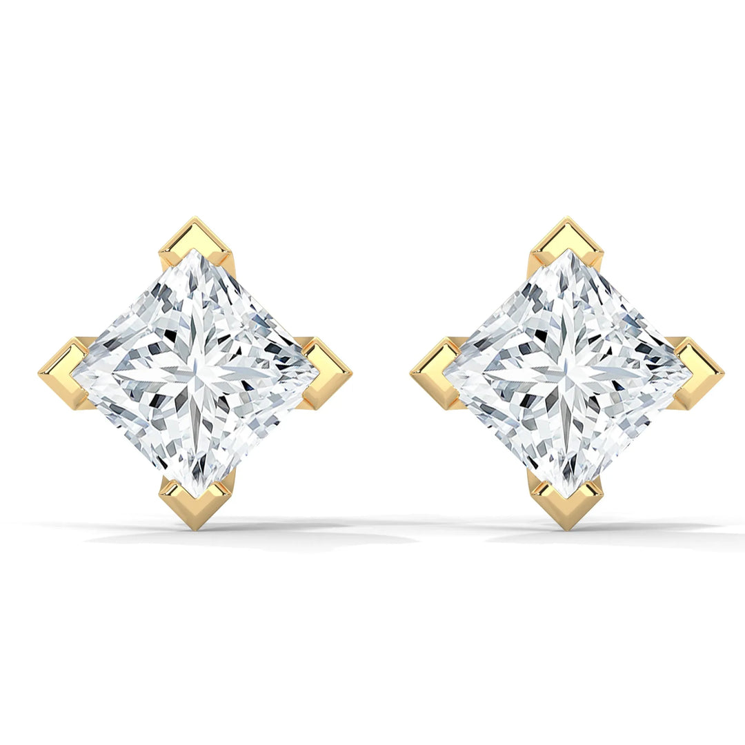 A pair of princess cut diamond stud earrings set in gold.