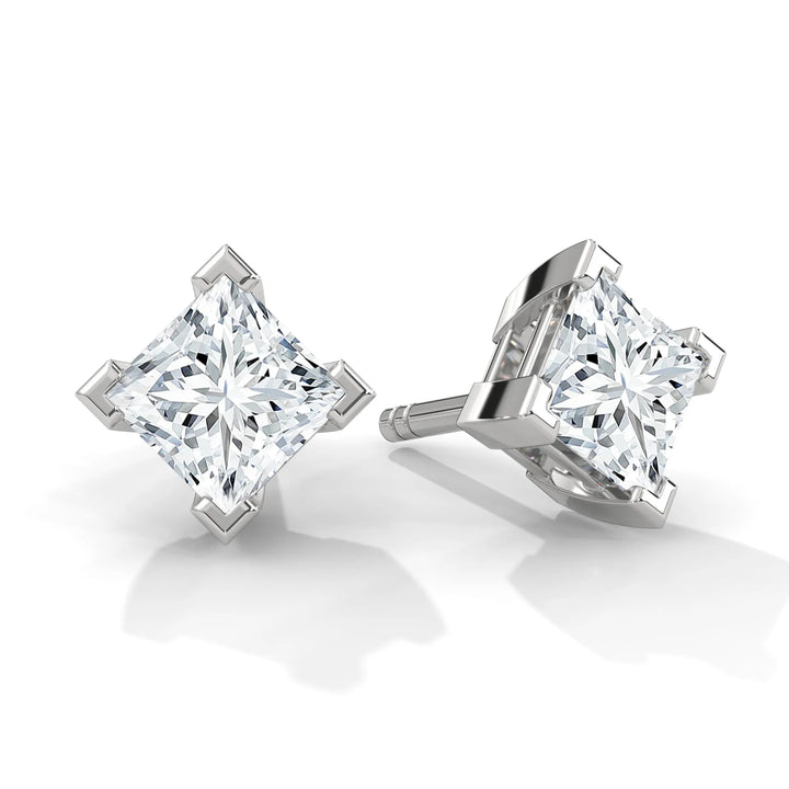 A pair of princess-cut diamond stud earrings on a white background.