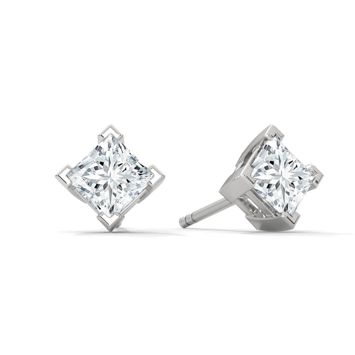 A pair of princess cut diamond stud earrings on a white background.