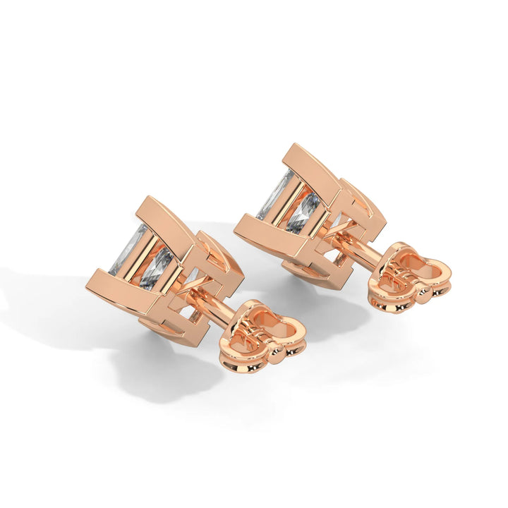 A pair of rose gold cufflinks with a rectangular design and central stones.