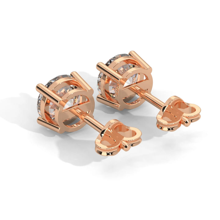 Pair of rose gold cufflinks with transparent gemstone detail on a white background.