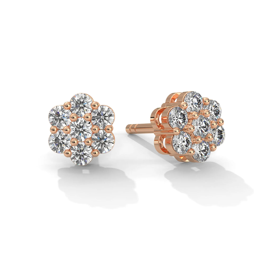 A pair of rose gold flower shaped diamond earrings on a white background.