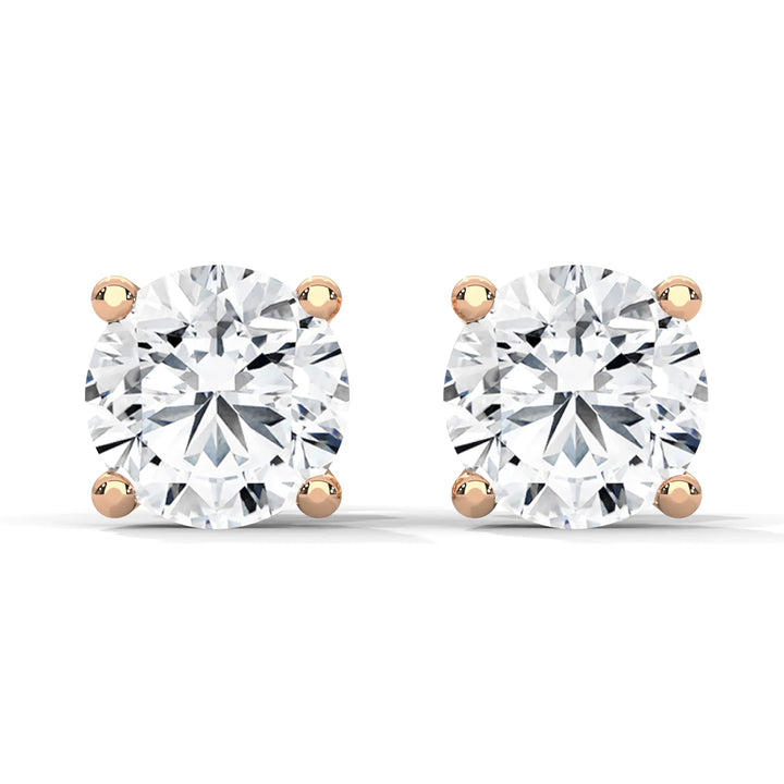 Pair of round cut diamond stud earrings with rose gold settings on a white background.