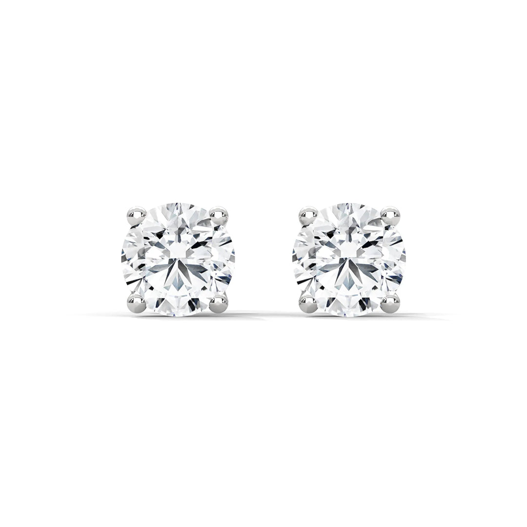 A pair of round cut diamond stud earrings with a white background.