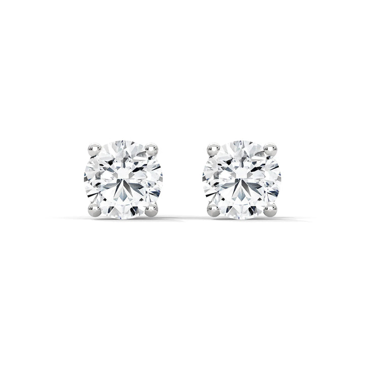 A pair of round cut diamond stud earrings with a white background.