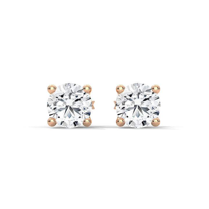 A pair of sparkling diamond stud earrings with gold settings on a white background.