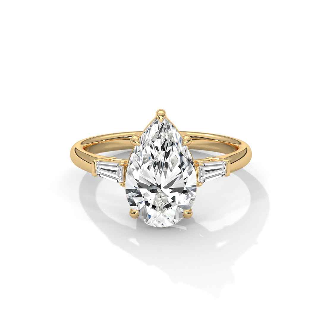 A pear-shaped diamond ring with a gold band and two baguette diamonds on each side. The ring is elegant, reflecting light with a sophisticated shine.