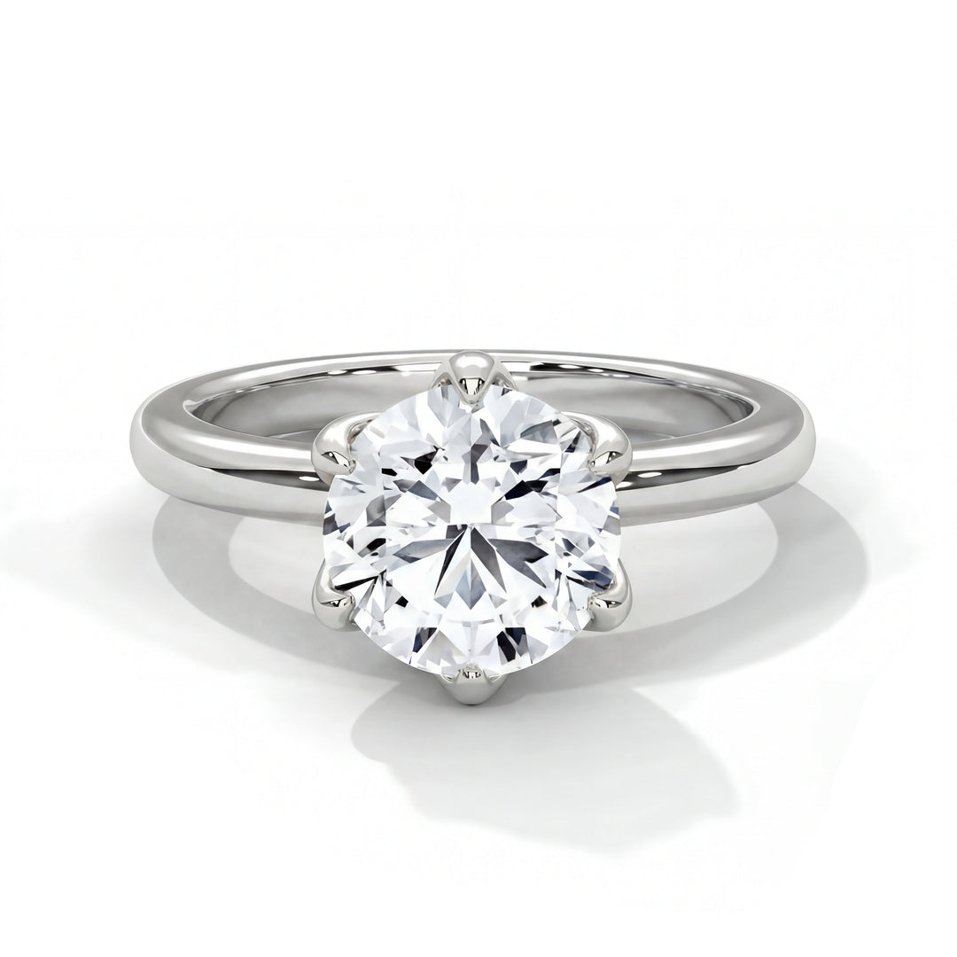 A platinum ring with a large, round-cut diamond set in a six-prong setting. The ring is elegant and polished, reflecting a sense of luxury and sophistication.