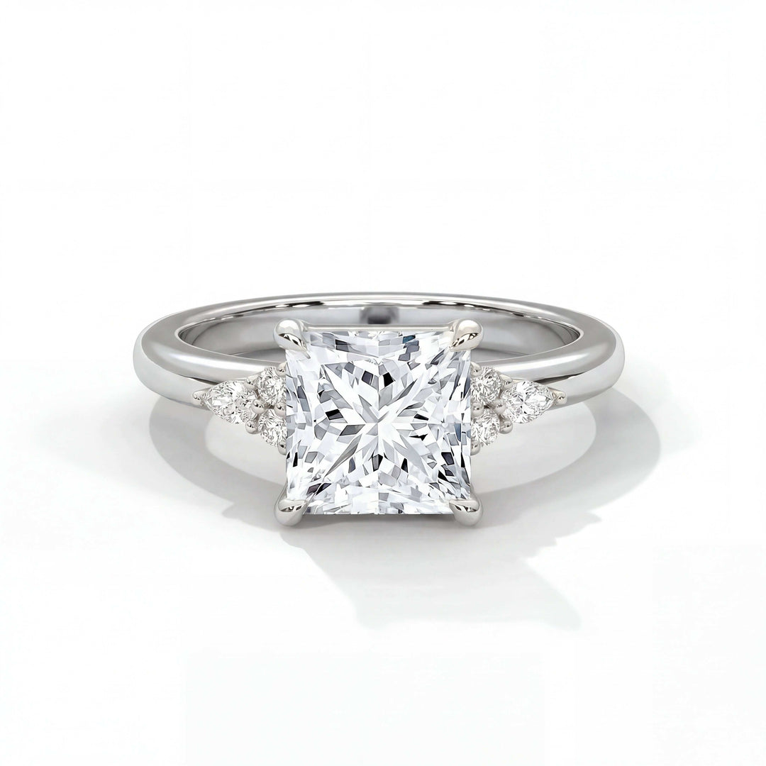 A radiant princess-cut diamond ring with a platinum band. Two smaller triangular diamonds flank the center stone, adding elegance and brilliance.