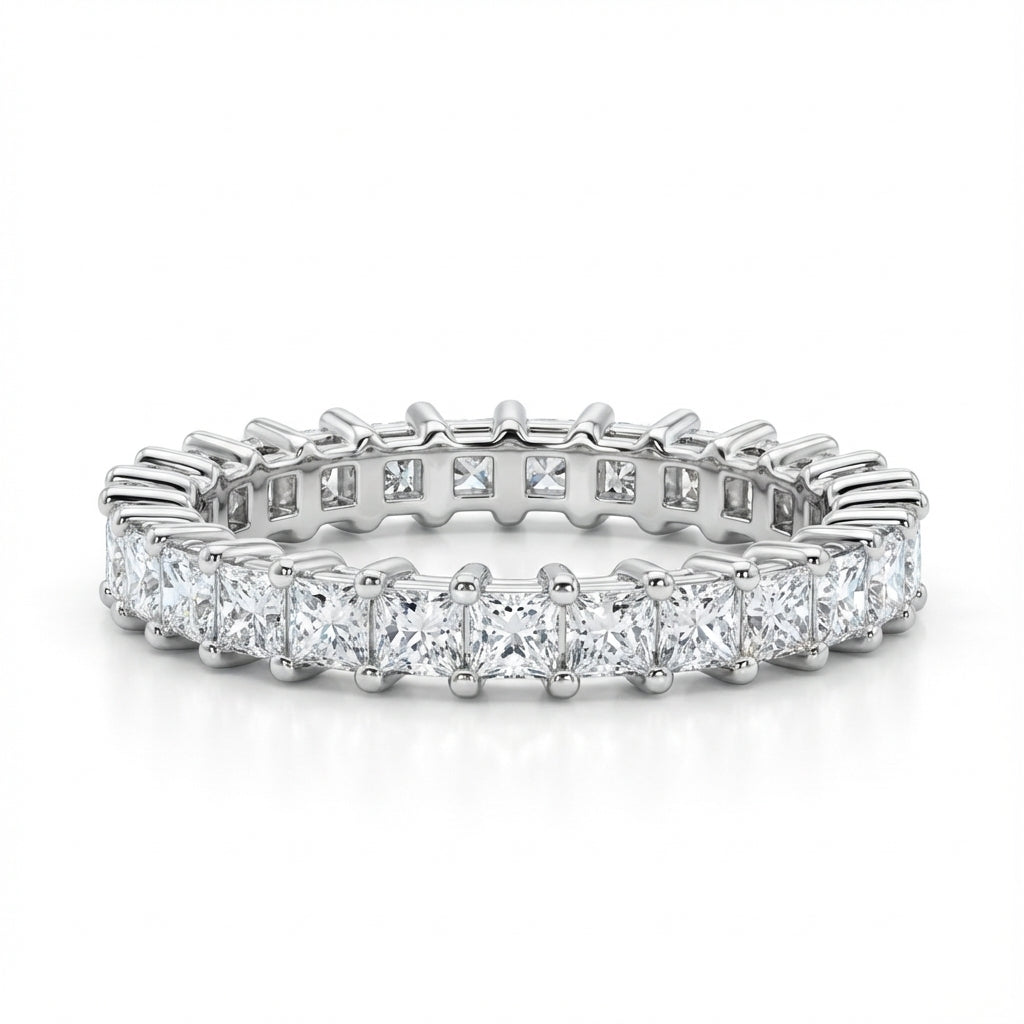 A radiant silver eternity ring set with square-cut diamonds encircles fully. The shimmering stones evoke elegance and luxury in a timeless design.