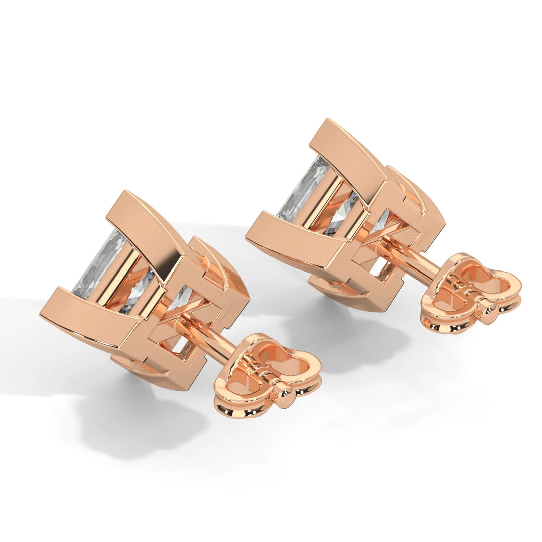 Rose gold cufflinks with a rectangular, clear gemstone on a white background.