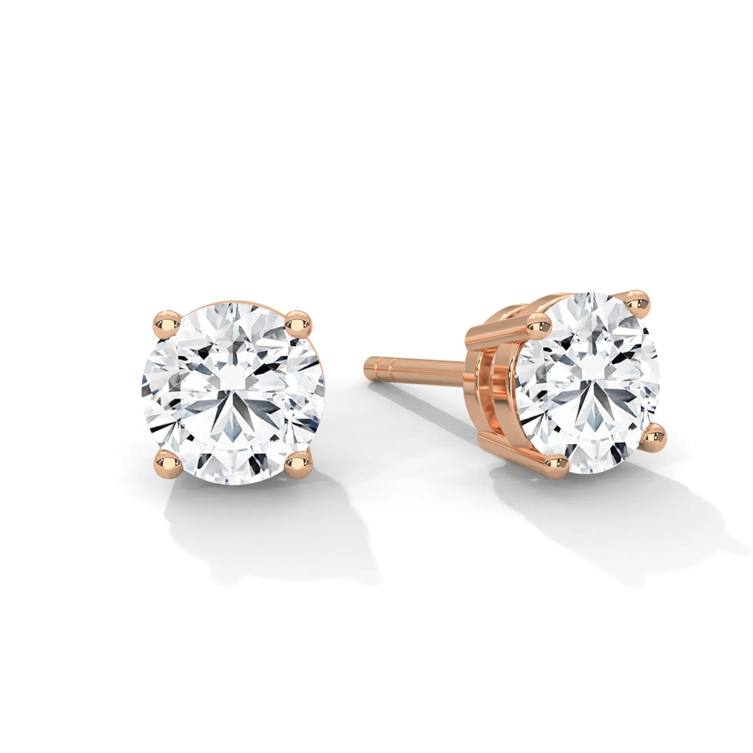 Pair of round cut diamond stud earrings with rose gold settings.