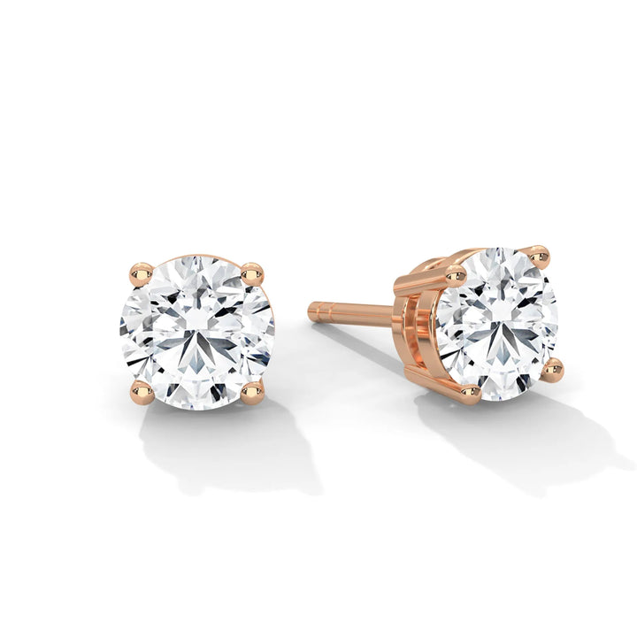 Pair of round cut diamond stud earrings with rose gold settings.